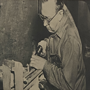 A man using a Superior Pneumatic needle scaler to remove rust from metal